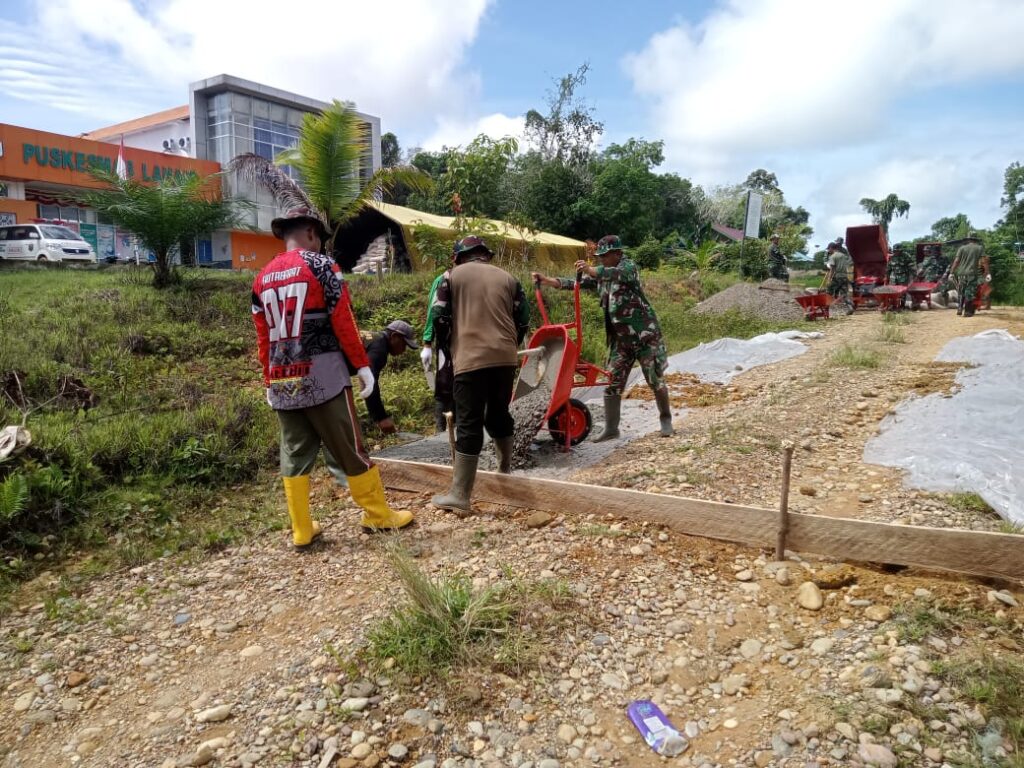Dengan Penuh Semangat, Anggota Satgas TMMD Melanjutkan Pembangunan Semenisasi Jalan