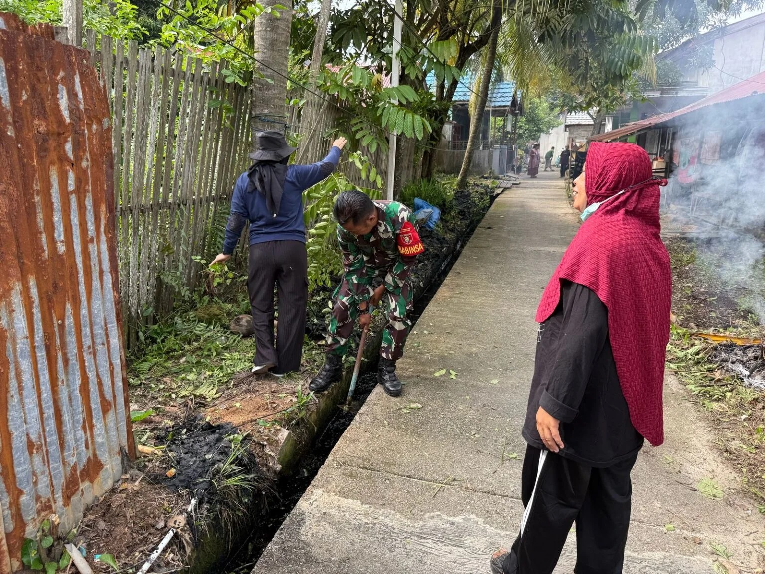 Bersihkan Parit dan Jalan, Babinsa Koramil 0908-01/Loktuan Kerja Bakti Bersama Staf Kelurahan dan Masyarakat