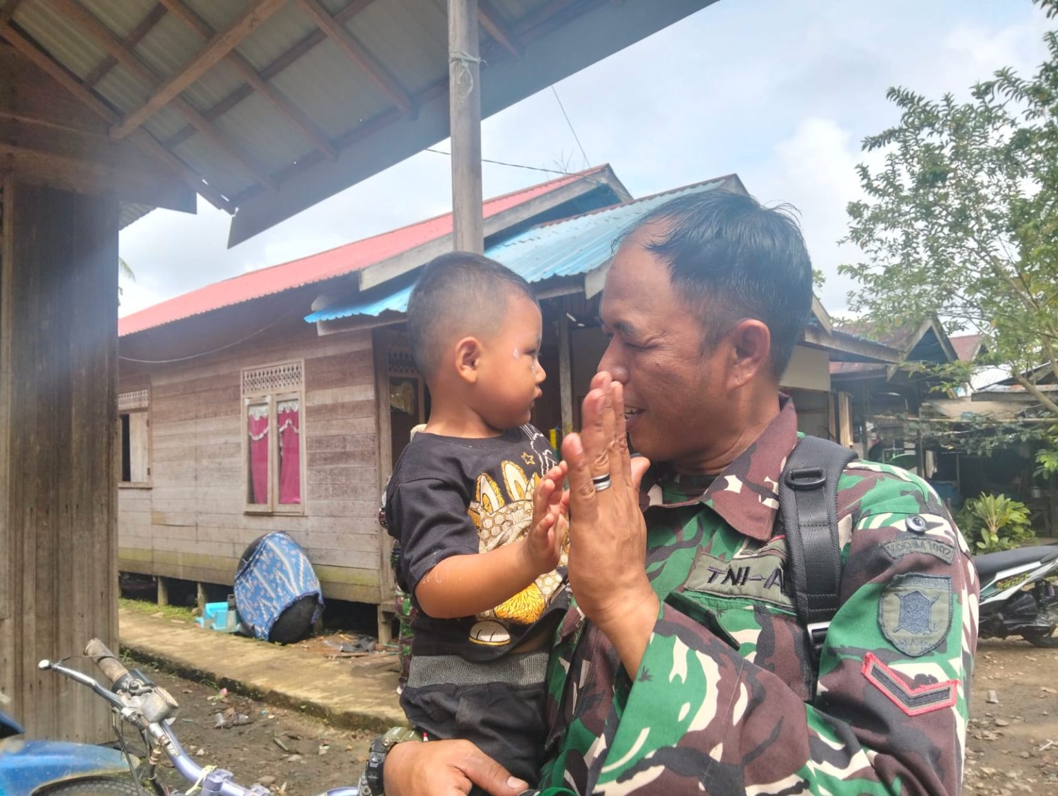 Obati Rindu Keluarga, Satgas TMMD ke-124 Kodim 1002/HST Gendong Anak Tetangga
