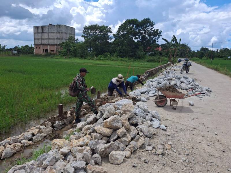 Babinsa Koramil 0908-03/Anggana Bersama Warga Gotong Royong Bangun Pondasi Pembatas Jalan Di Desa Binaan
